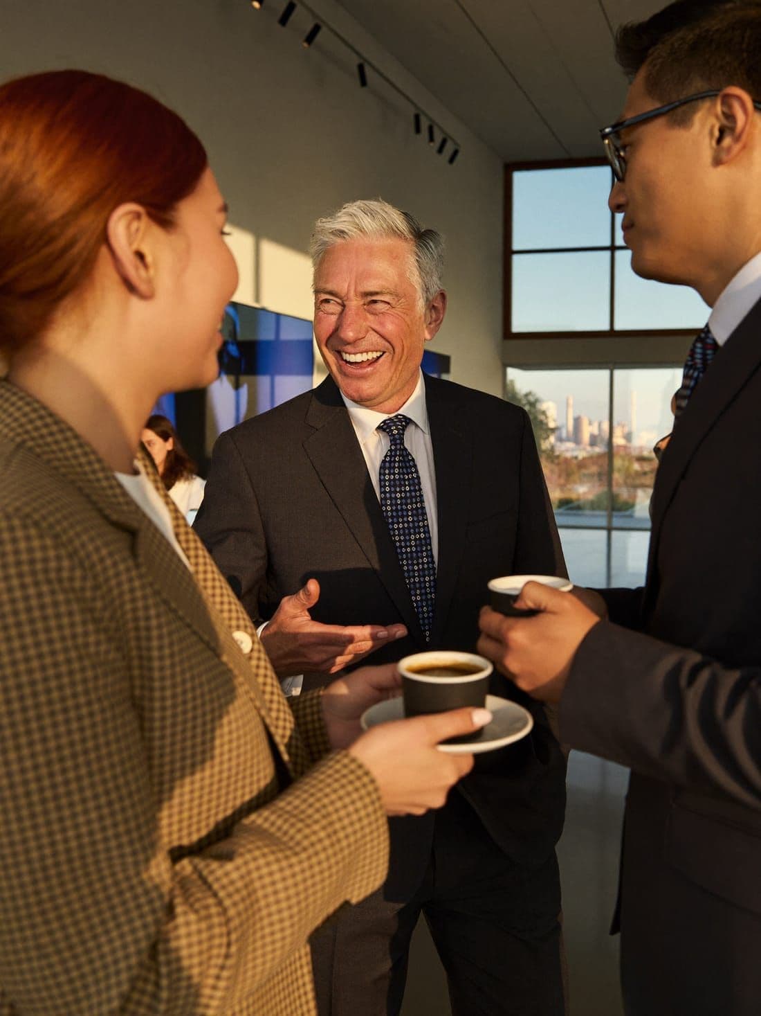 Professionals laughing together at a conference mixer